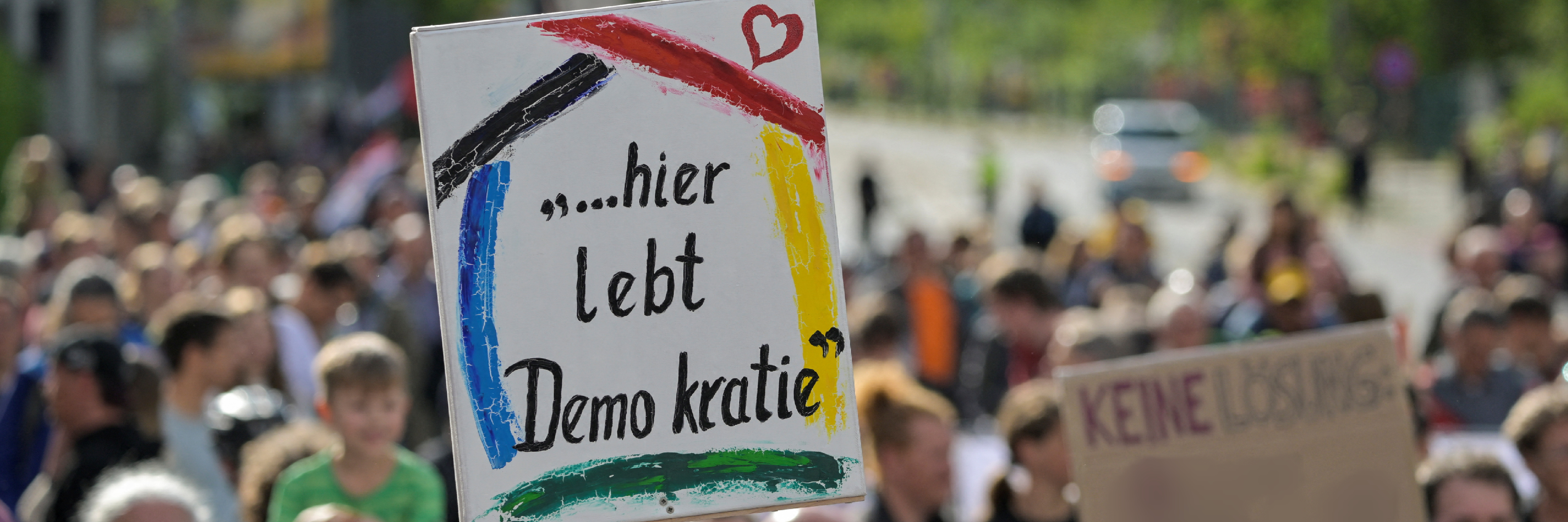 Demonstranten mit Plakat "Hier lebt Demokratie"