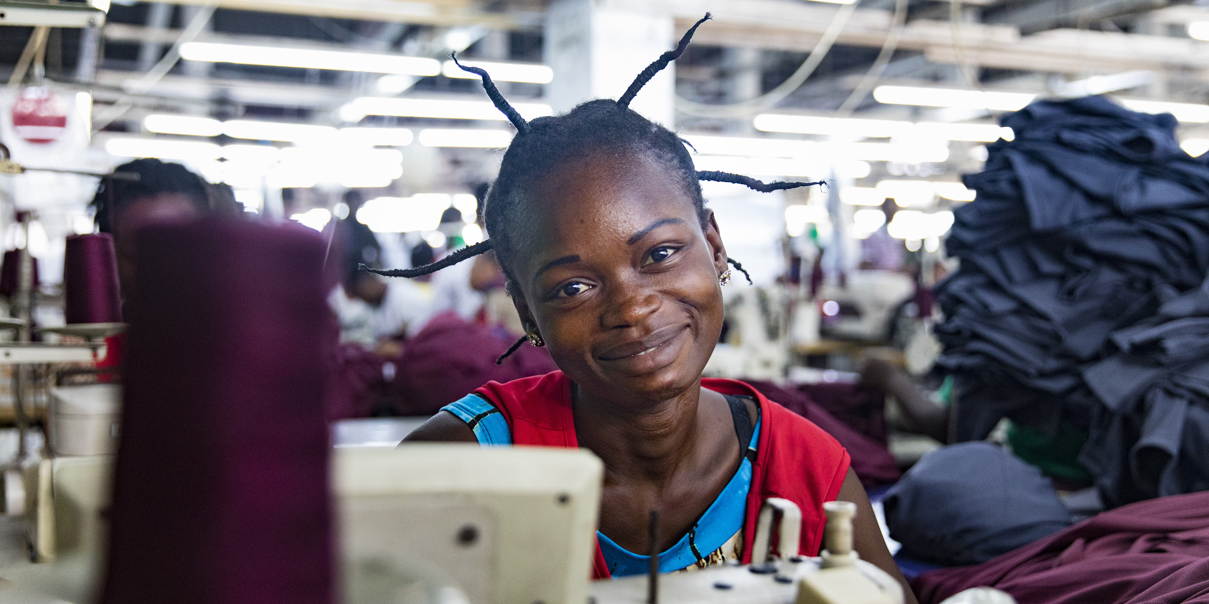 Junge Näherin in der Textilfabrik Dignity