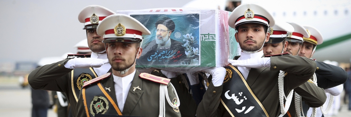 Uniformierte iranische Armeemitglieder tragen den beflaggten Sarg von Präsident Raisi über ein Flughafen-Rollfeld