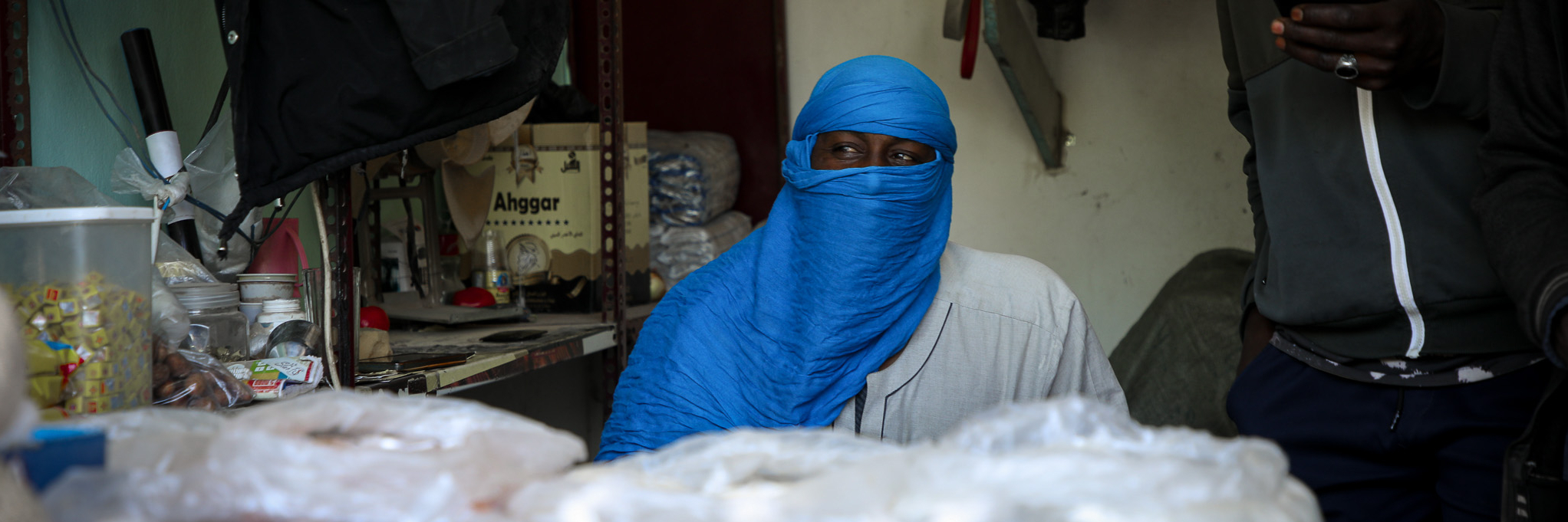 Arbeitsmigrant in Tripolis Libyen an einem Verkaufstand mit leuchtend blauem Turban.