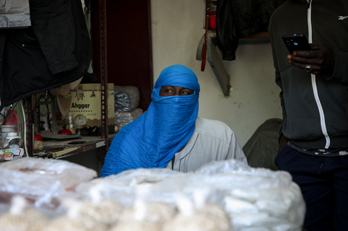 Labour migrant in Tripoli Libya at a stall with a bright blue turban.