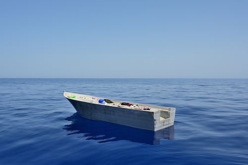 An abandoned refugee boat is adrift at sea. It was previously cleared by the Libyan coast guard.