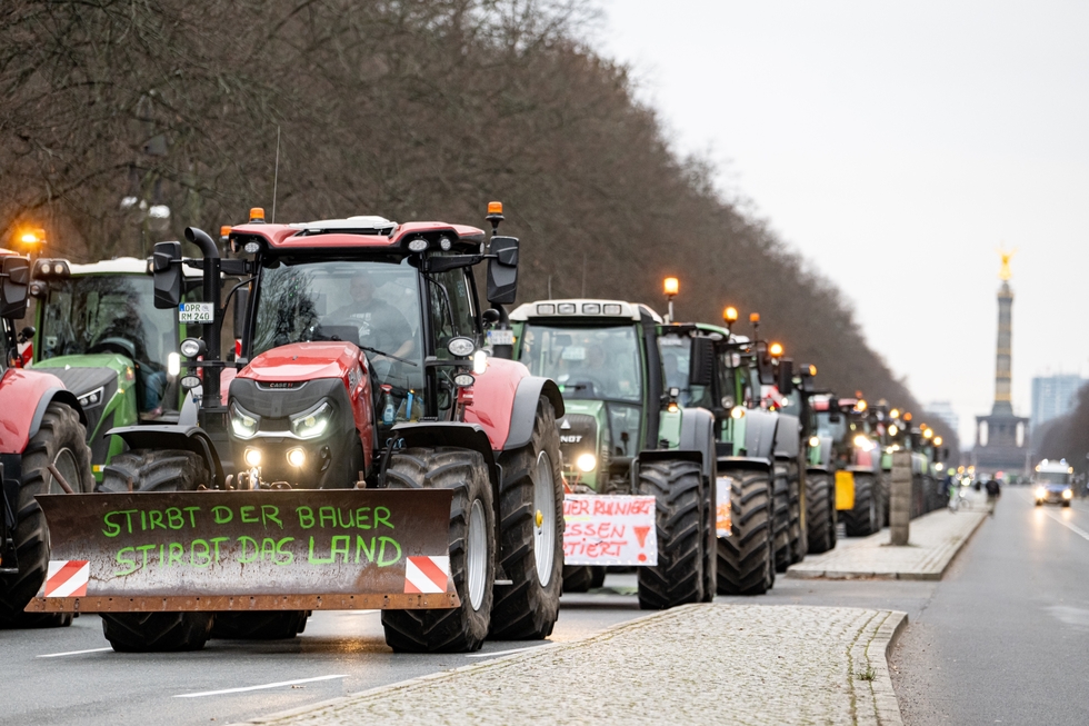 Eine Reihe Traktoren auf einer Demo auf der Straße des 17. Juni in Berlin, der erste trägt die Aufschrift "Stirbt der Bauer, stirbt das Land"