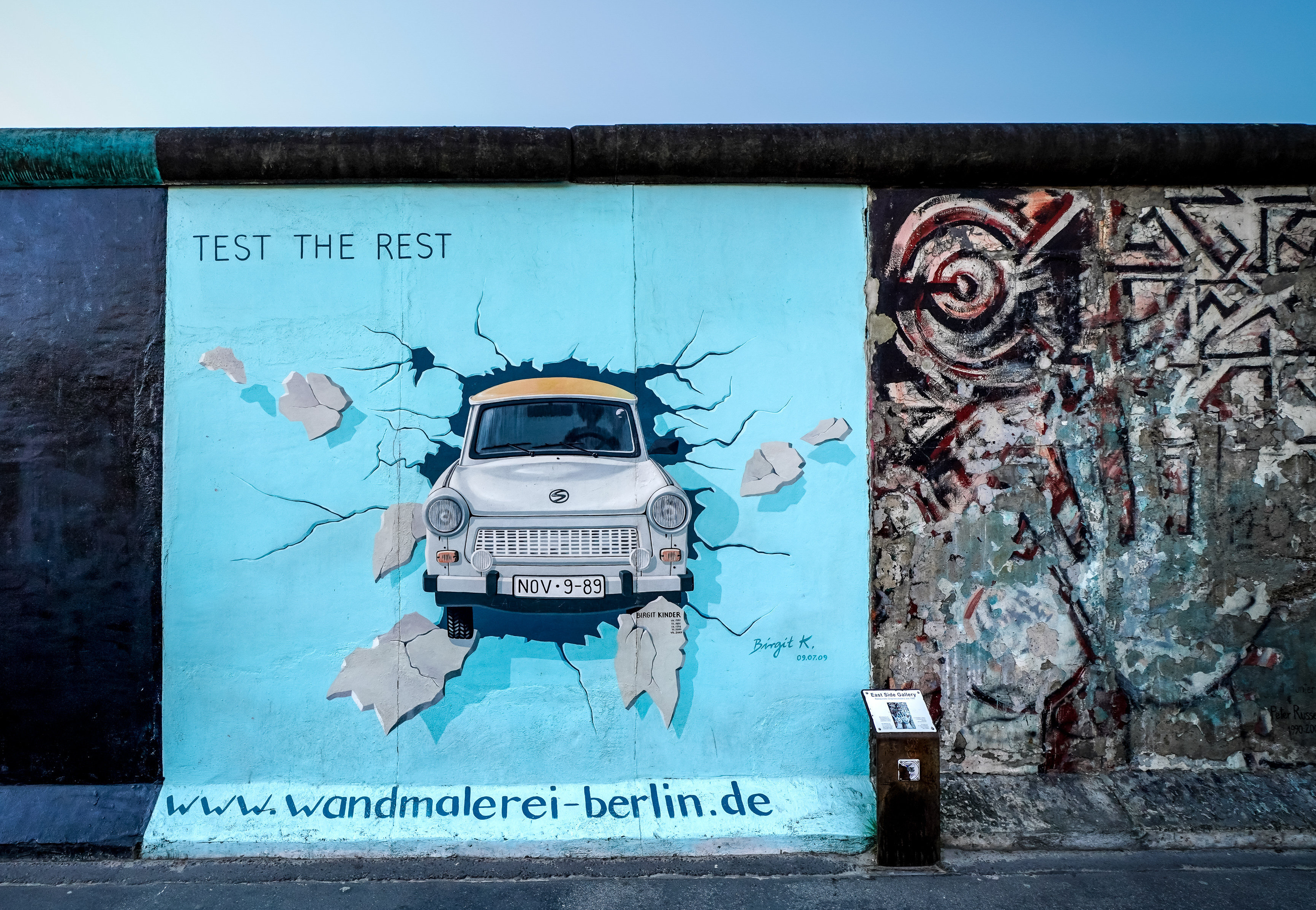 Ein Stück Berlinermacher mit einem Bild von einem Trabi, welcher durch die Mauer hindurchbricht.