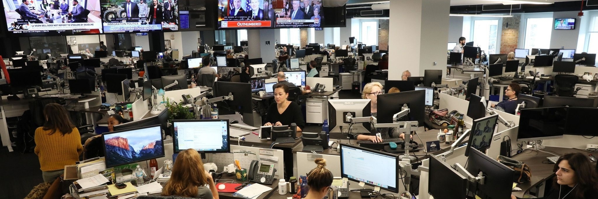 Journalist*innen in dem Newsroom einer Nachrichtenredaktion