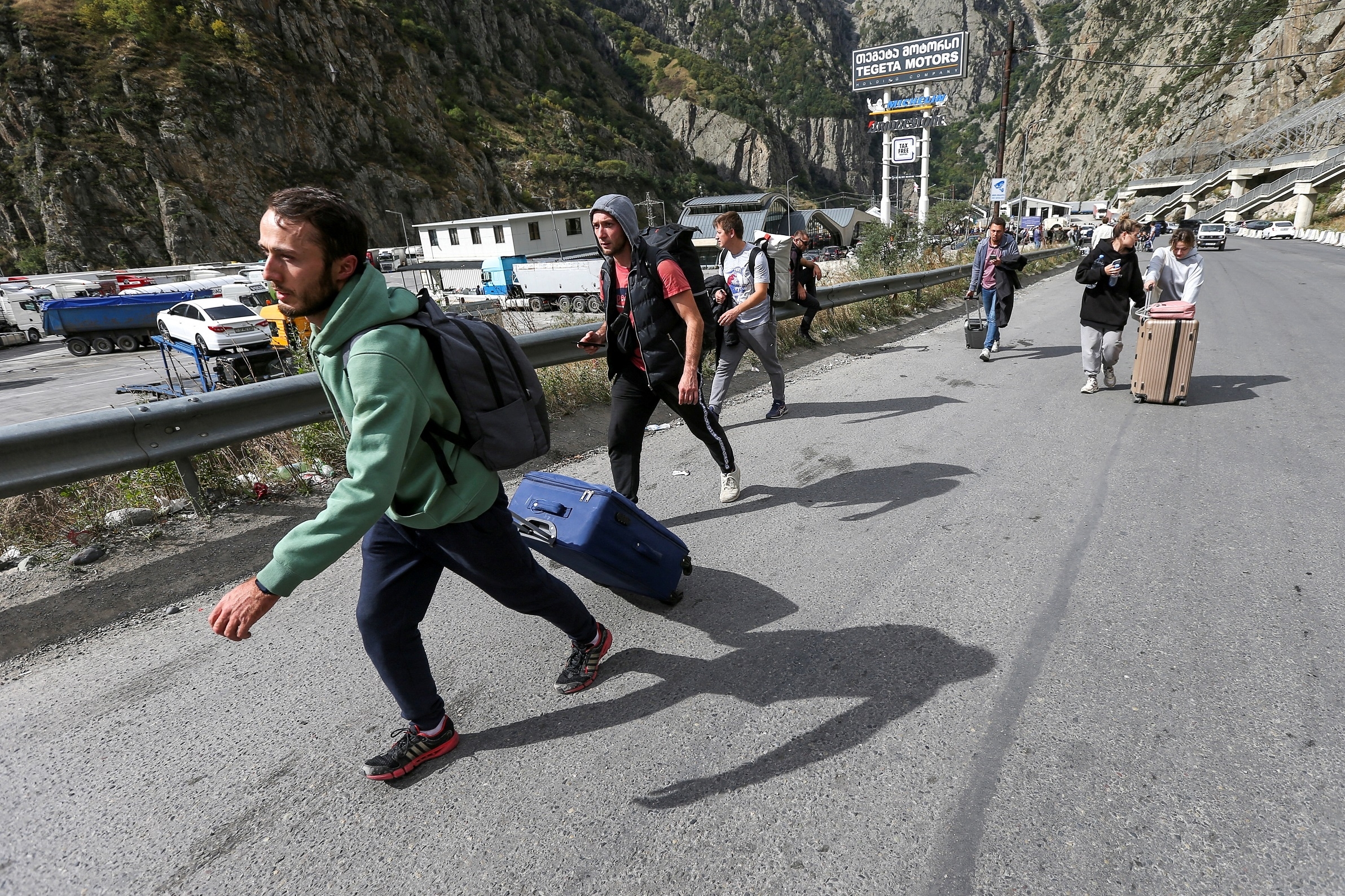 Travellers walk after crossing the border with Russia at the frontier checkpoint Verkhny Lars - Zemo Larsi, Georgia September 28, 2022. 