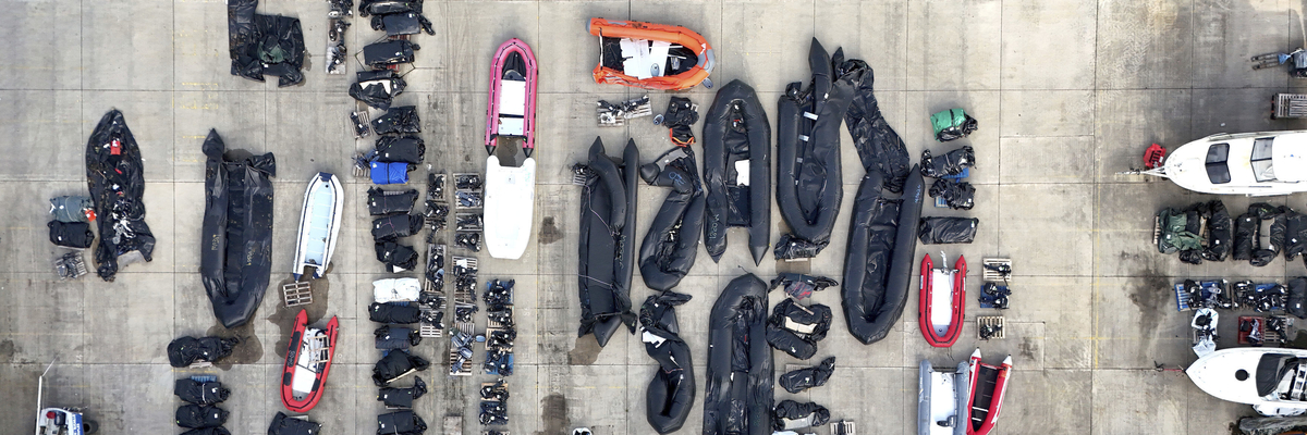 Luftansicht von einer Reihe an Schlauchbooten und Außenmotoren an einem Hafen