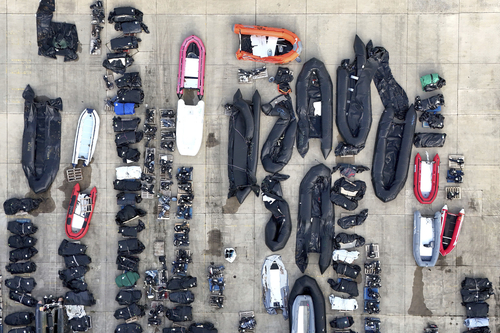 Luftansicht von einer Reihe an Schlauchbooten und Außenmotoren an einem Hafen