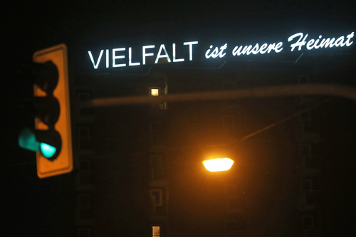 The light installation entitled ‘Diversity is our strength’ by artist Christoph Stark shines from the roof of a high-rise building. The words Diversity is our home can be read.